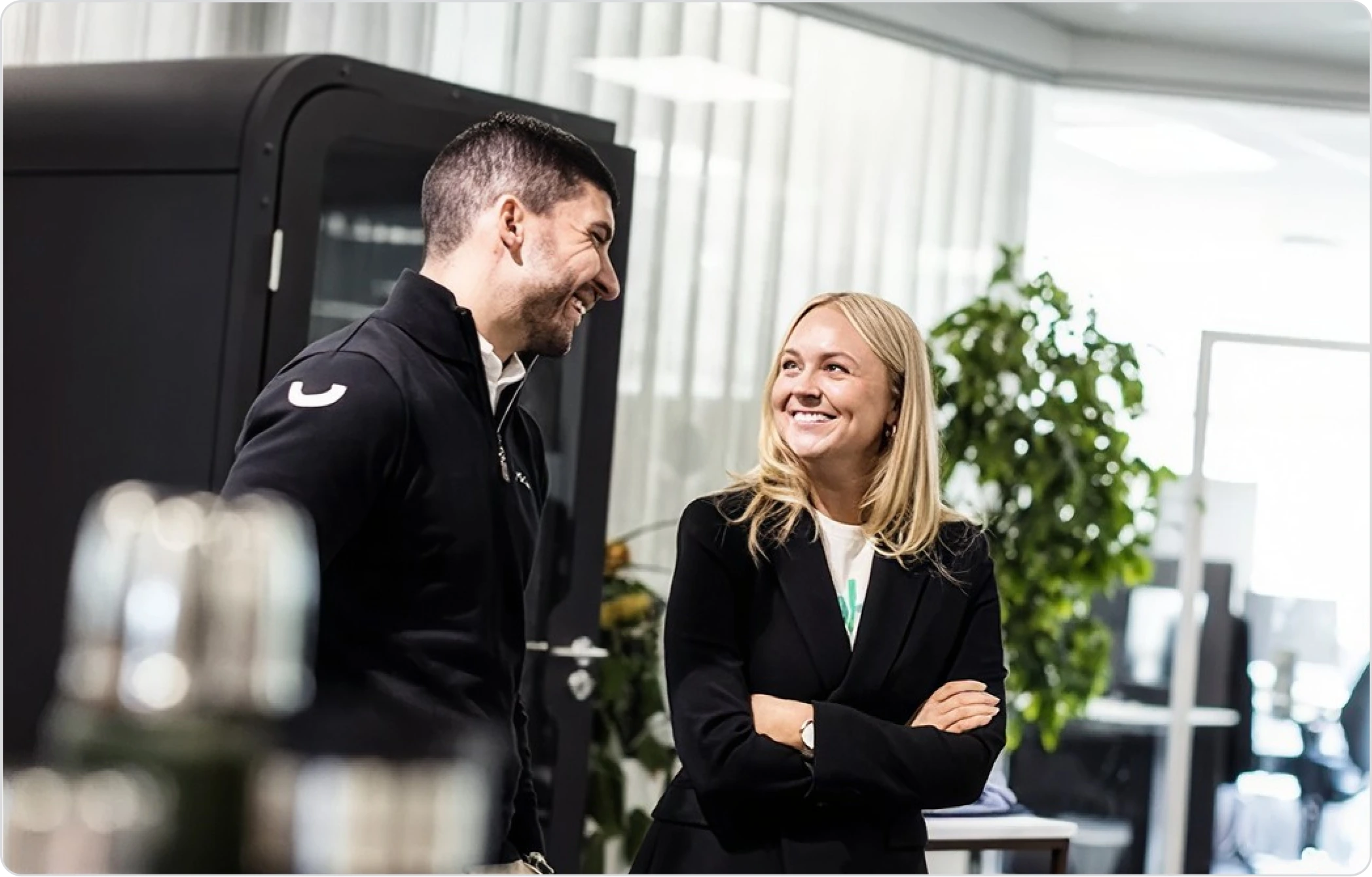 Två kollegor i Vokys kontor med profilkläder på bordet bredvid dem.